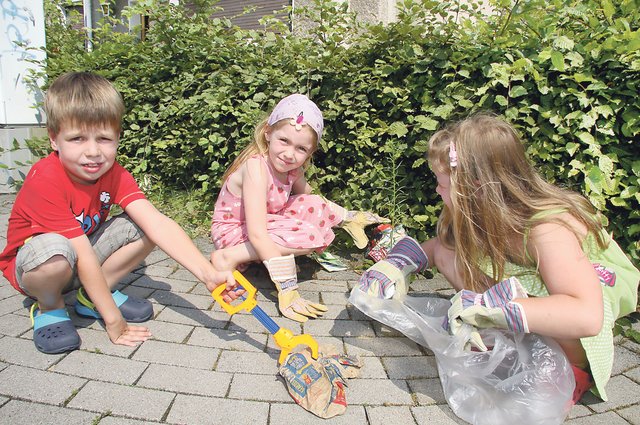 Luis und seine Freundinnen Lena (Mitte) und Anna beim Müllsammeln.