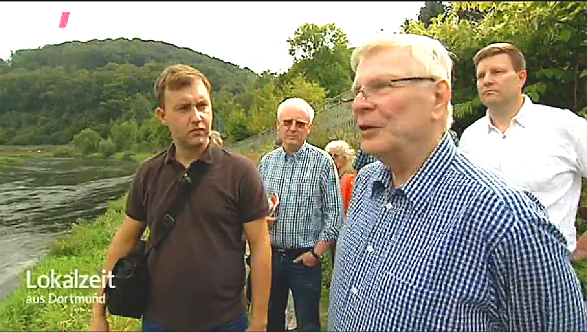 Naturführer Martin Maschka (links) mit einigen Hattingern in dem WDR-Fernsehbericht in der Lokalzeit Dortmund vor Ort am Winzer Ruhrbogen. Hier soll die Ruhr renaturiert werden, die Buhnen verschwinden und stellenweise auf 90 Meter verbreitert werden. Quelle: WDR