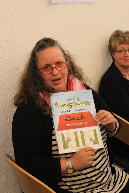 Nora Herbst zeigt das Buch "Zwei Ungeheuer unter einem Dach"