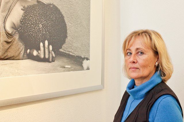 Angelika Schilling vor einem ihrer Porträts aus der Serie "Ihr Gesicht sieht man nicht" ihres Projekts "Menschen, die auf der Straße leben".