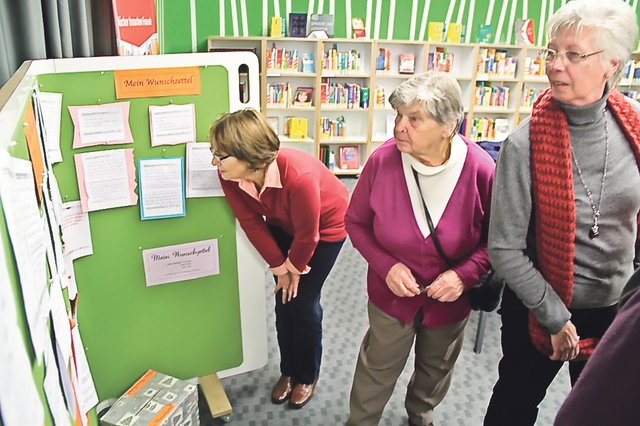 Gleich nach der kurzen Veranstaltung gingen die ersten Neugierigen an die Stellwand mit den ausgehängten Wünschen. Diese sind inzwischen in der Stadtbibliothek „gewandert“: von der ersten Etage hinunter in die Nähe des Aquariums – der besseren Erreichbarkeit wegen. Foto: Römer