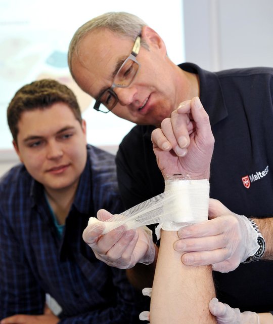 Ausbilder Friedhelm Vater zeigt das richtige anlegen eines Druckverband