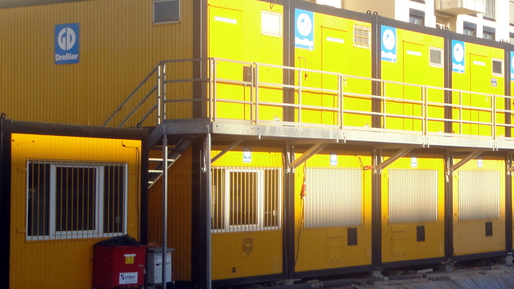 Wohncontainer sind schnell errichtet und können notfalls gestapelt werden. Im Bild: Gelbe Baucontainer mit Aufenthalts- und Büroräumen. Wohncontainer sind in der Regel hellgrau gehalten.