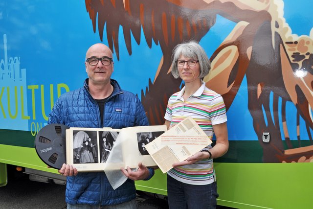 Intendant Ralf Ebeling mit Filmrolle und Fotoalbum sowie Katharina Tiemann vom LWL-Archiv mit alten Zeitungsartikeln.