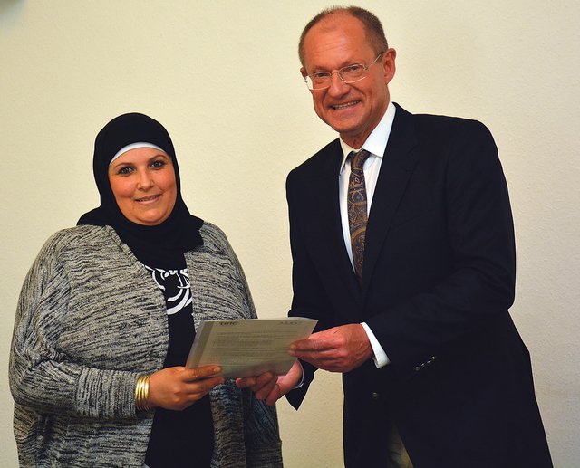 Bürgermeister Ulrich Roland bei der Verleihung des Sprachzertifikats an eine Teilnehmerin.