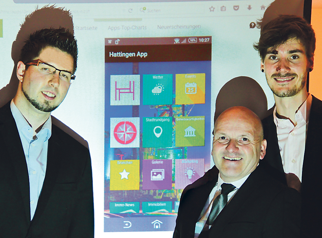 Nein, kein Gruselbild, sondern die Schatten werfenden Macher der neuen kostenlosen Hattingen-App vor einer mit einem Beamer angestrahlten Leinwand mit der Ansicht eben der Hattingen-App: (v.l.) David Schulz von PrismaIT, Georg Hartmann von Hattingen Marketing und Ideengeber Philipp Stalter. Foto: Römer