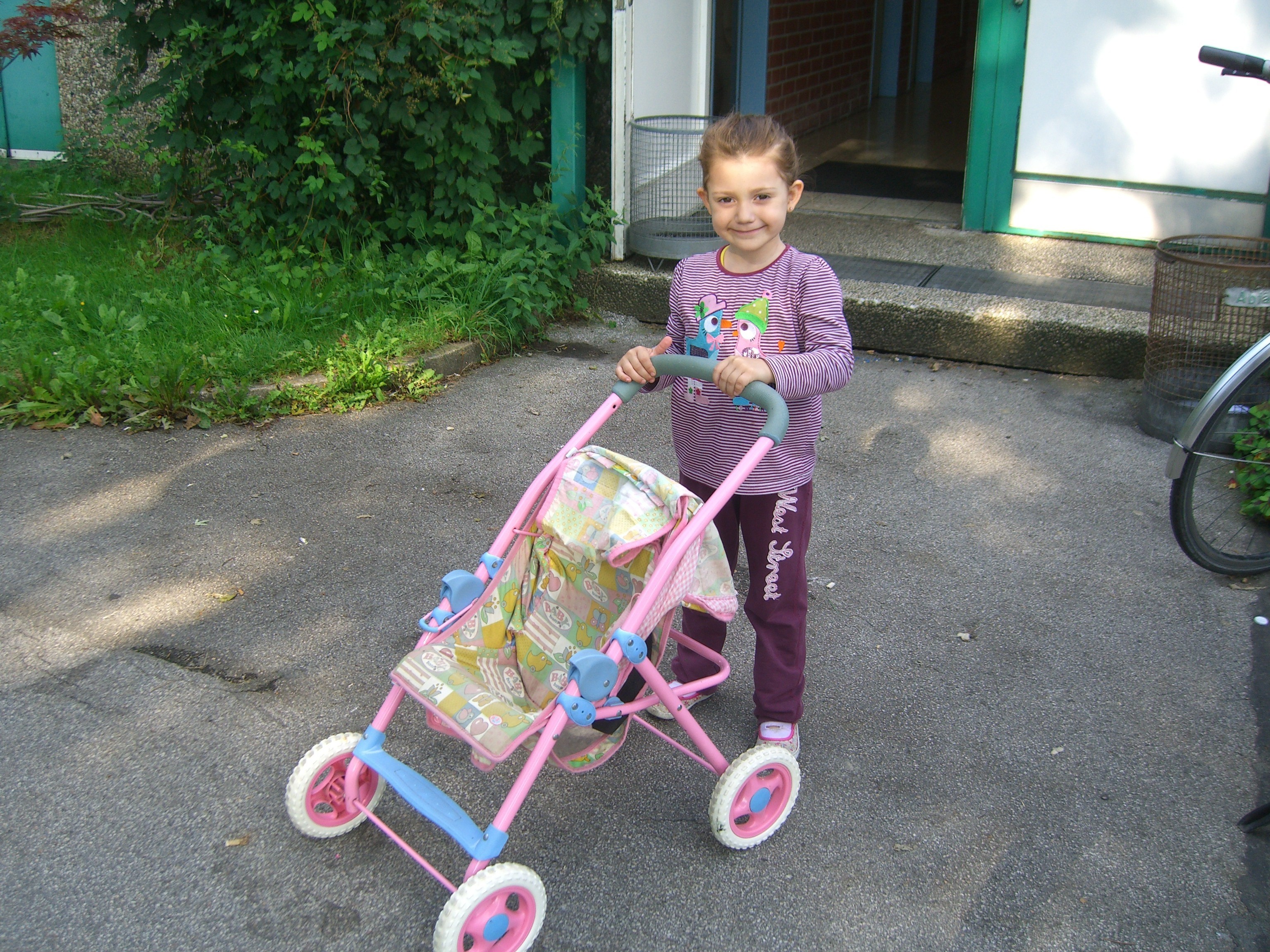 Das vierjährige Flüchtlingskind Aldea strahlt. Sie ist glücklich mit ihrem leeren Puppenwagen. Fotos: Schattberg