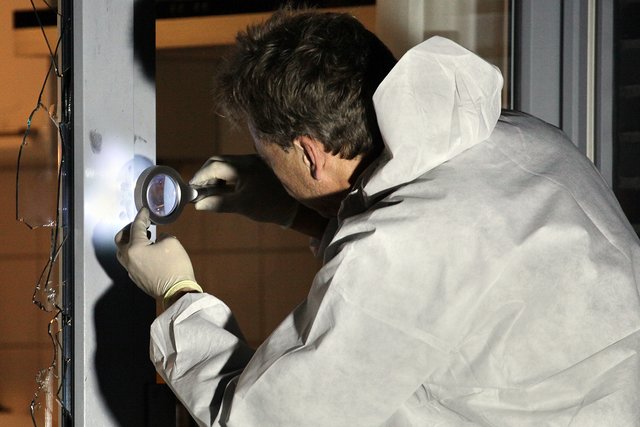 Ein Kriminaltechniker nimmt Spuren unter die Lupe. | Foto: Magalski