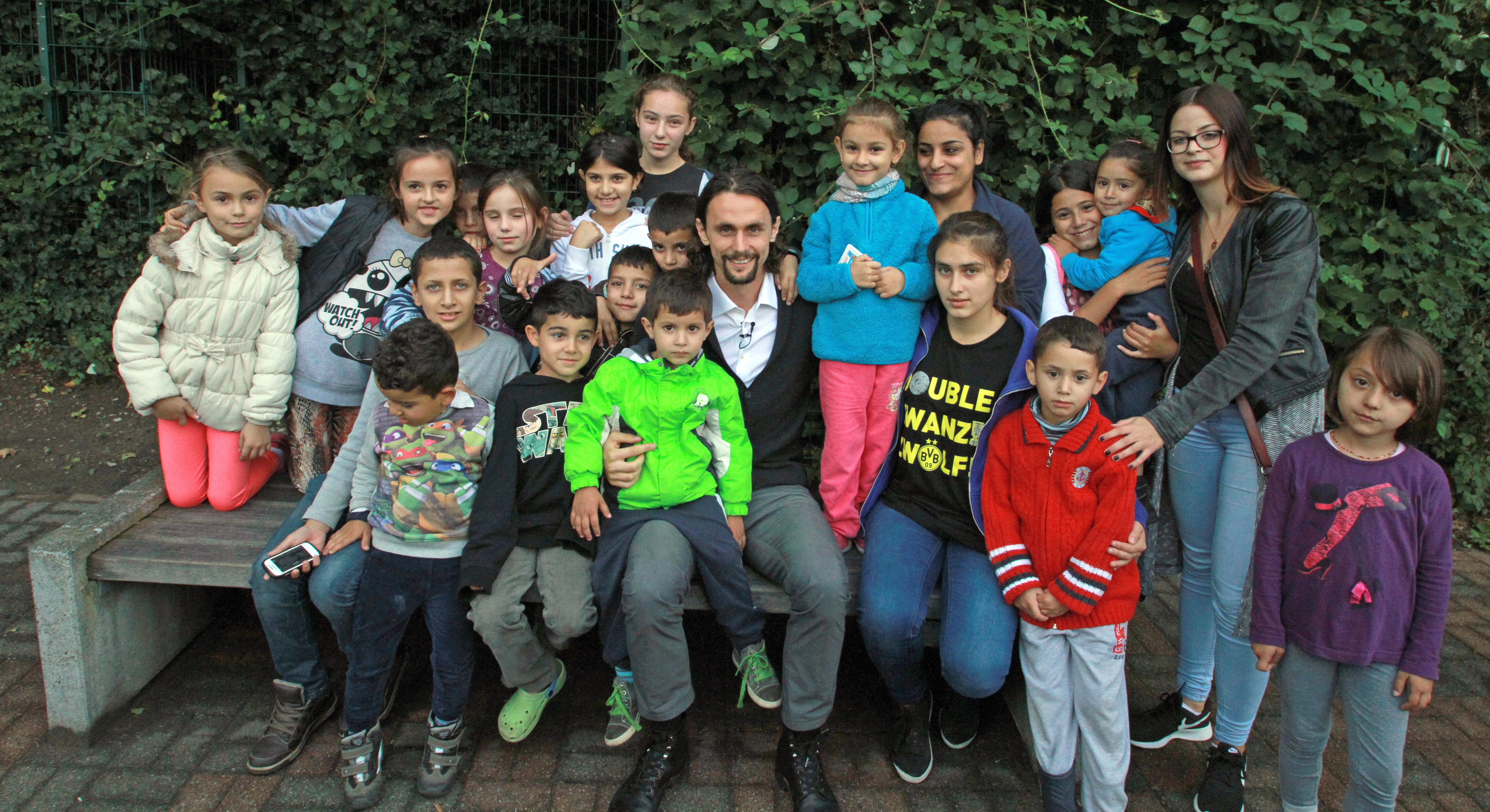 Der BVB-Star zum Anfassen: Neven Subotic hatte am Besuch genau so viel Spaß wie die Kinder und Erwachsenen der Unterkunft. Rechts oben im Bild ist Sophia Jäger zu sehen, die Lünerin hilft den Flüchtlingen ehrenamtlich und hatte Subotics Besuch mit arrangiert.