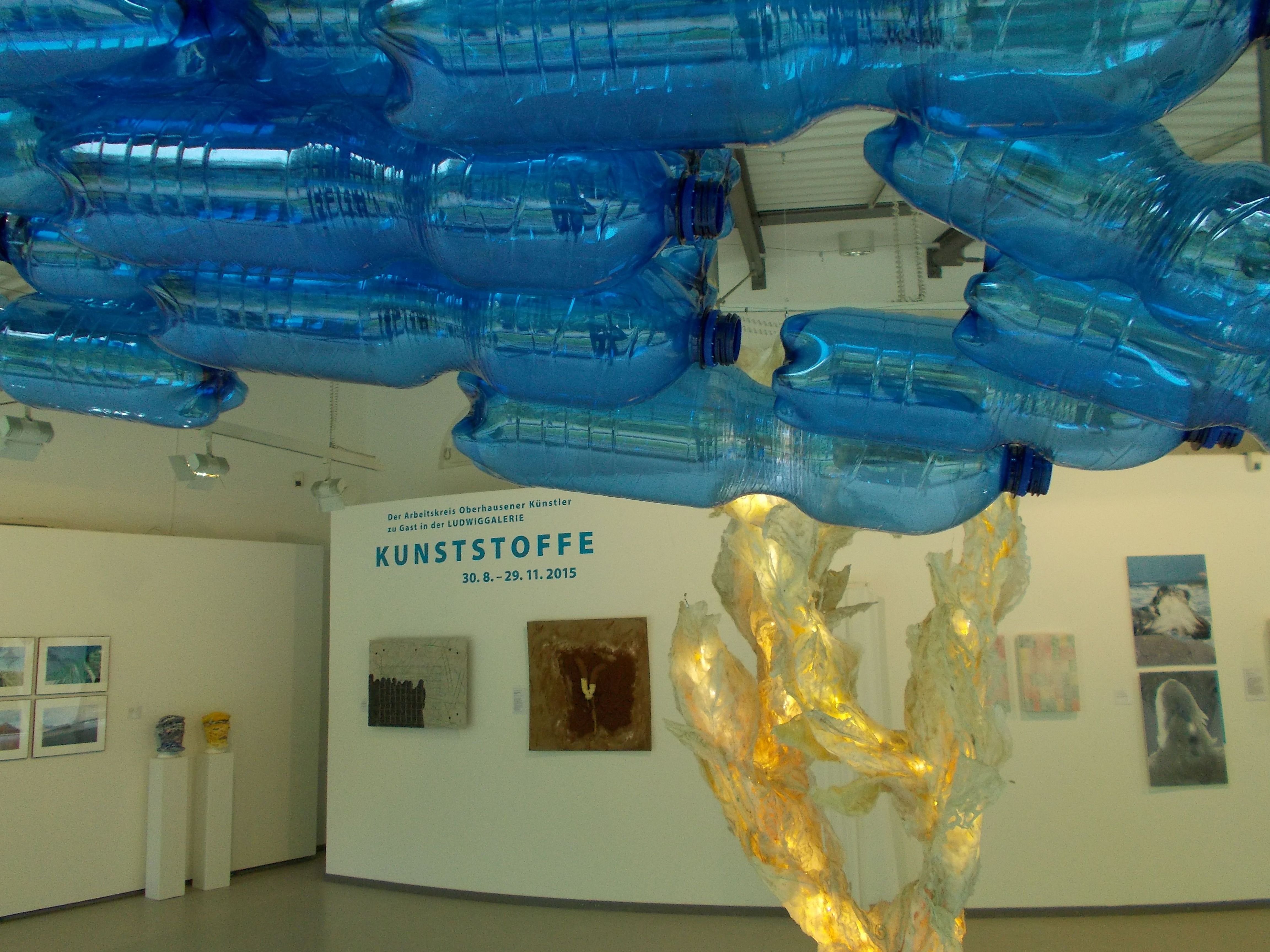 Blick in die Ausstellung "Kunststoffe", mit "Petmen" (blaue Kunststoffflaschen) von Helmut Kottkamp