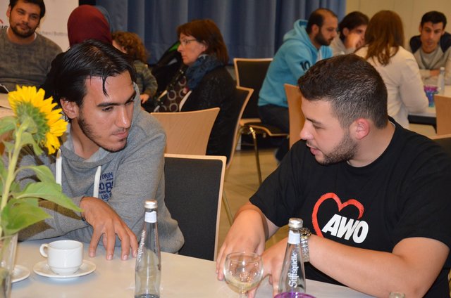 Karim Ahmed (r.) versucht an vielen Tischen als Übersetzer zwischen den Flüchtlingen und den ehrenamtlichen Helfern zu vermitteln, indem er übersetzte. | Foto: Janina Rohden