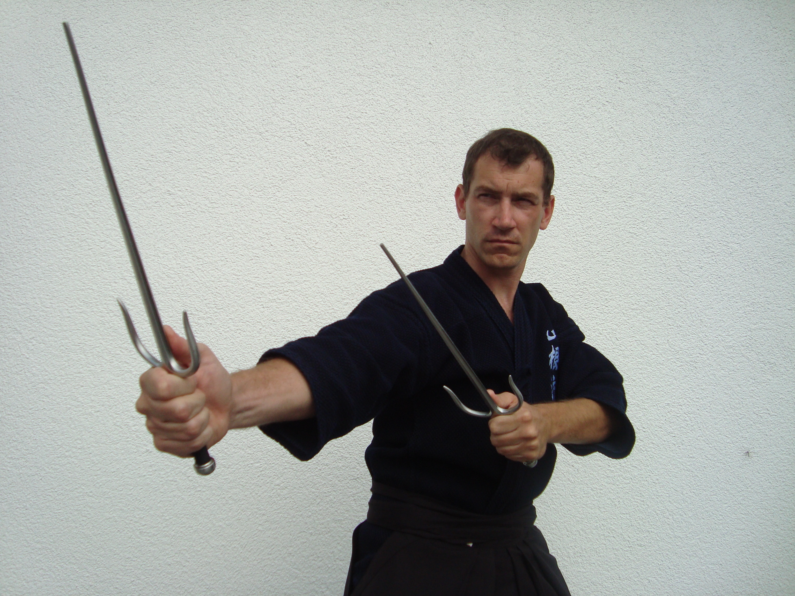 Schulleiter Thomas Heinze mit der Kobudo-Waffe Sai