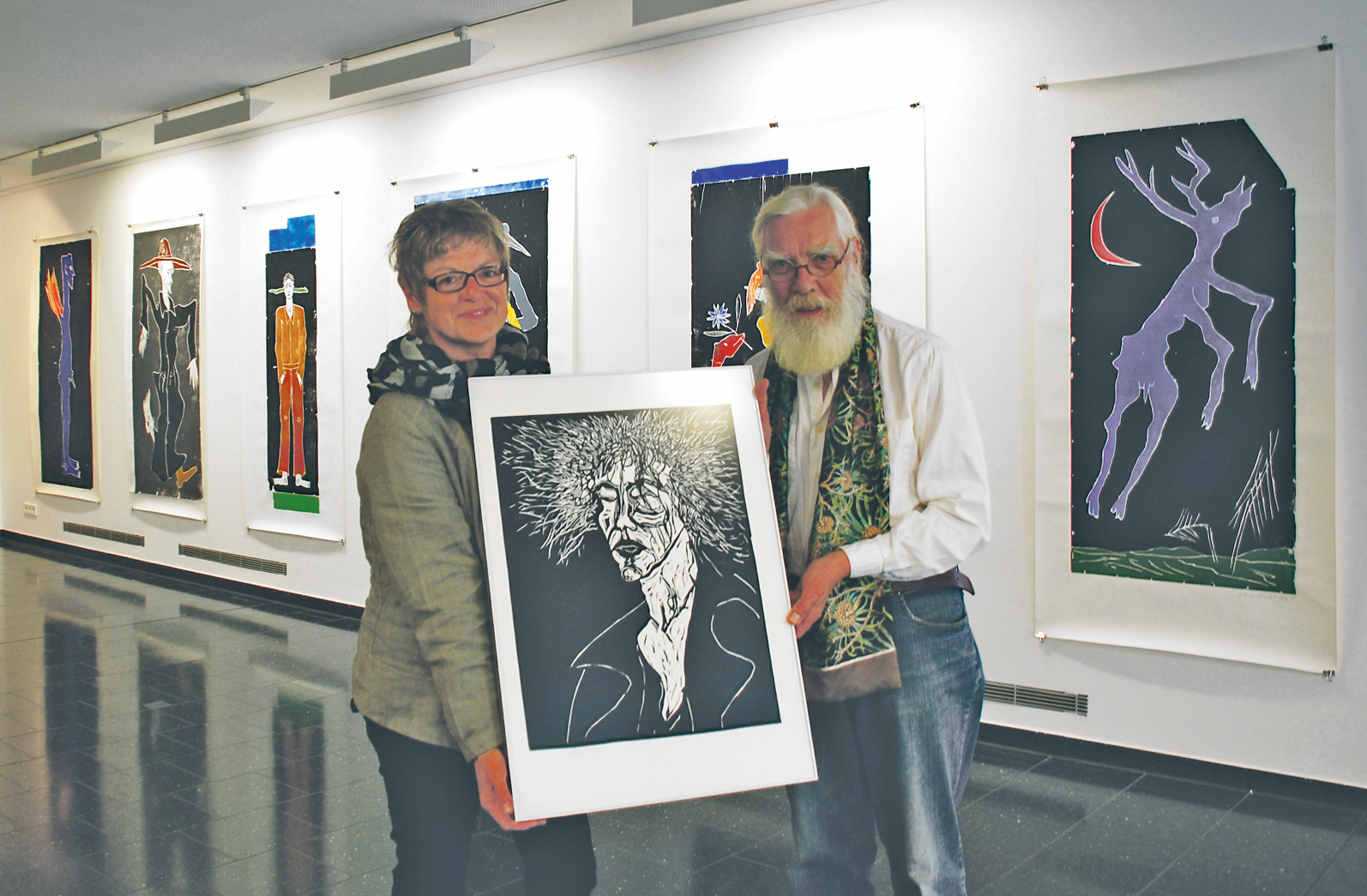 Gudrun Schwarzer, Leitung des Stadtmuseums Hattingen, und Werner Reuber mit einem der ersten Linoleumdrucke des Düsseldorfer Künstlers, der einen Teil seiner Werke unter dem Titel „Halbe Wahrheiten“ bis zum 8. November ausstellt.