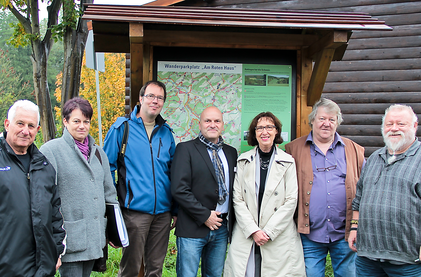 Die braune Bretterwand rechts hinten gehört zum Wartehäuschen neben dem Wander-Parkplatz „Am Roten Haus“ an der Elfringhauser Straße/Ecke Felderbachstraße. Vor der neuen Info-Tafel für Wandertouristen haben sich die „Macher“ aufgereiht: (v.l.) Heinz Kalinowski (Ideenschmiede), Solveig Holste (Stadtbetriebe und Tiefbau), Ulrich Kestler vom Presse- und Informationsbüro, Georg Hartmann (Stadtmarketing), Bürgermeisterin Dr. Dagmar Goch, Peter Becker und Ulrich Plitt (beide Ideenschmiede). Foto: Römer