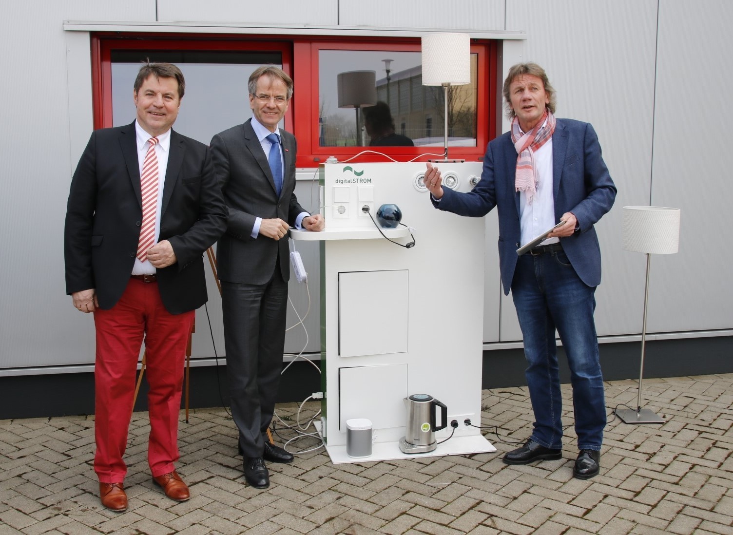 Innungs-Obermeister Georg Eickholt, Kammerpräsident Andreas Ehlert und Uwe Isenbügel zeigen Smart-Home-Anwendungen.
