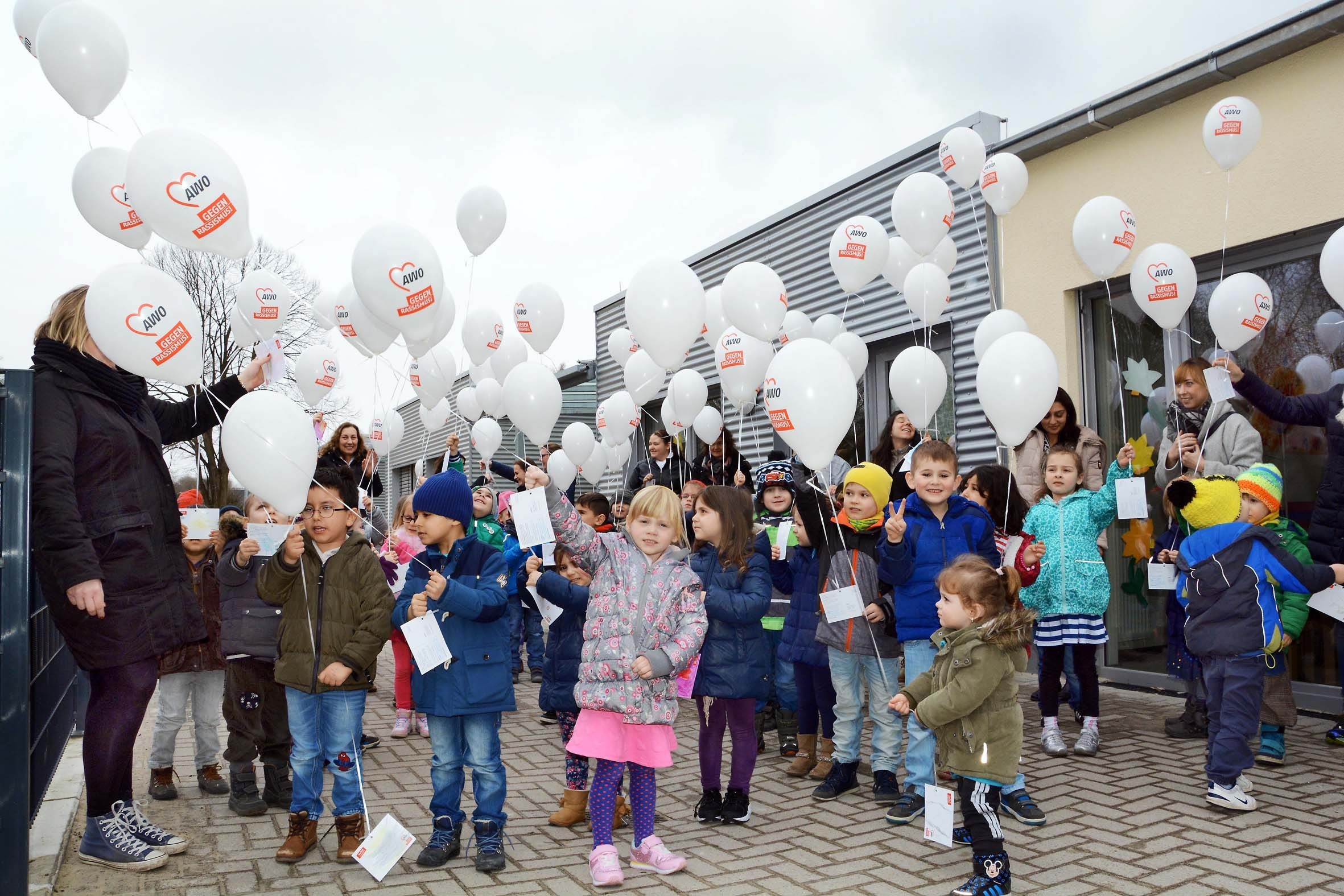 Kita-Kinder, Erzieherinnen und Eltern ließen an der Wambeler AWO-Kita "Auf dem Hohwart" weiße Luftballons gegen Rassismus in den Himmel steigen.