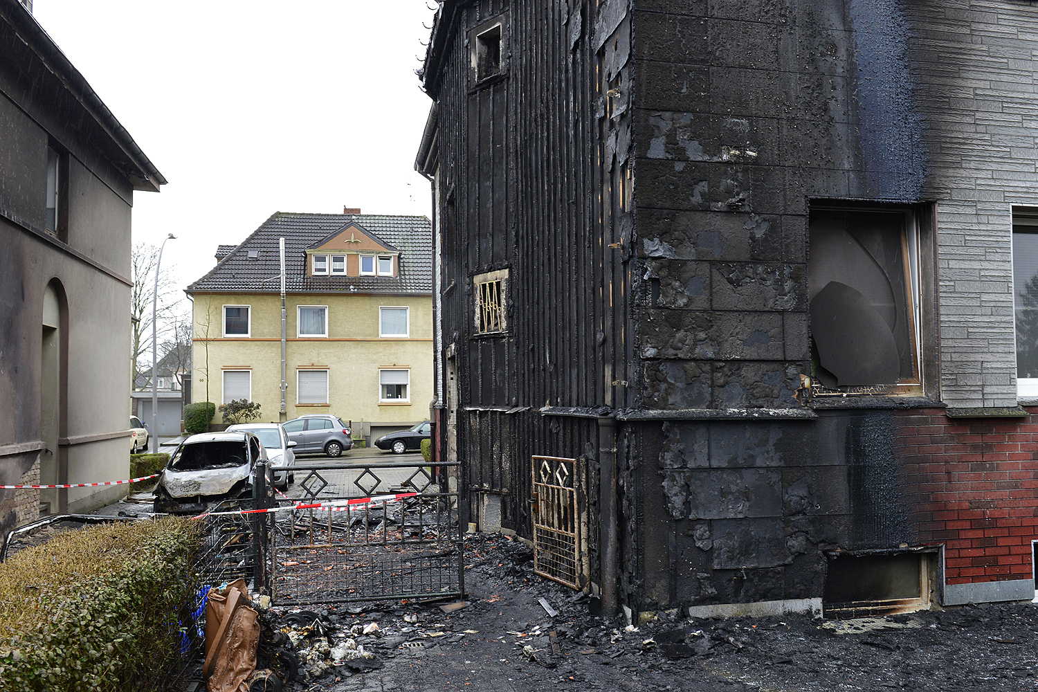 Ein in der linken Hauseinfahrt abgestellter Wohnwagen brannte vor dem PW (li.) völlig aus. Zu Vermuten ist, das der Brand sich von dort aus entwickeln konnte. Die genaue Brandursache muss aber noch untersucht, bzw. geklärt werden. Foto: Kariger
