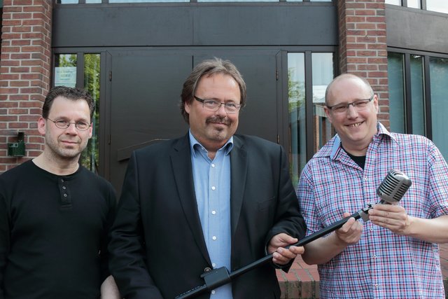 Mit Charme und Mikro, dem Wahrzeichen des Vereins, Ludger van Bebber (Kassenwart), Olaf Broekmans (1. Vorsitzender) und Jörg Regier (2. Vorsitzender)