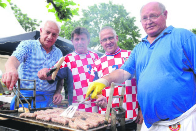 Bürgermeister Frank Schneider (2.v.r.) als Zapf- und Grillmeister am Stand des kroatischen Vereins. Foto: Michael de Clerque