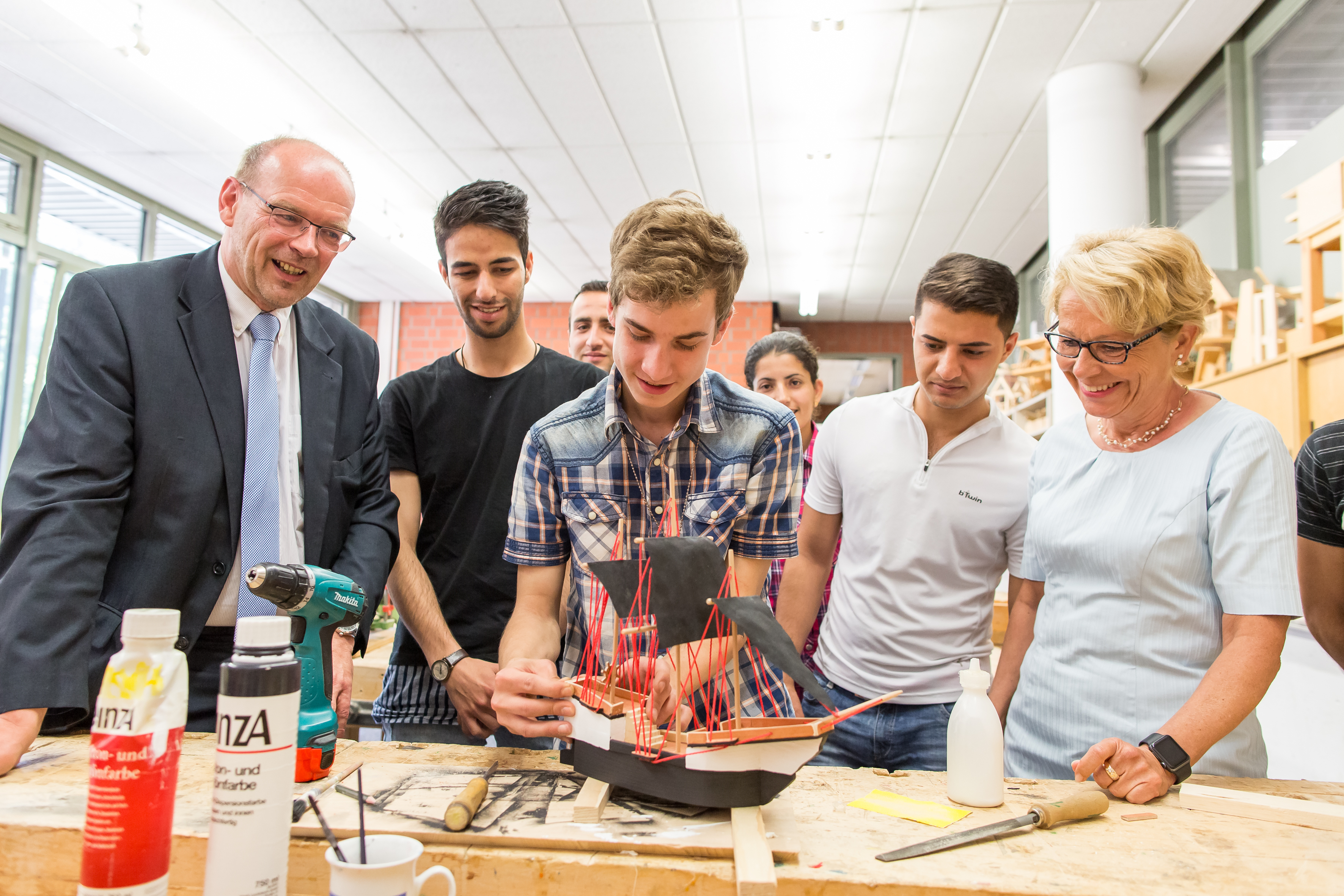 Rainer Schmeltzer (l.) und Bärbel Bergerhoff-Wodopia (r.), mit Teilnehmern des Bildungsprojektes für Flüchtlinge im Bildungszentrum des TÜV NORD Bildung in Bergkamen. Foto: Nikelowski