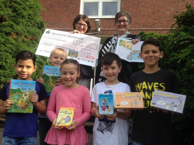Die Kinder der Herder-Grundschule im Gretelweg in Eving freuen sich über viele neue Lernspiele und Bücher, die der Förderverein der Schule dank der 2500-Euro-Spende von der Gemeinwohl-Stiftung der Sparkasse Dortmund kaufen konnte. Im Bild freuen sich mit den Kindern die Fördervereins-Vorsitzende Eva Blumberg (links) und Sabine Bartz, Vorstandsmitglied der Gemeinwohl-Stiftung der Sparkasse Dortmund. // Foto: Drechsel