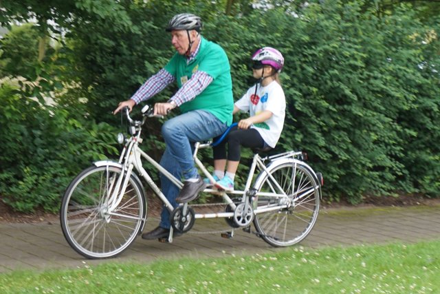 Tandem-Pilot Günther Kraus fährt ein Schulkind mit verbundenen Augen.
