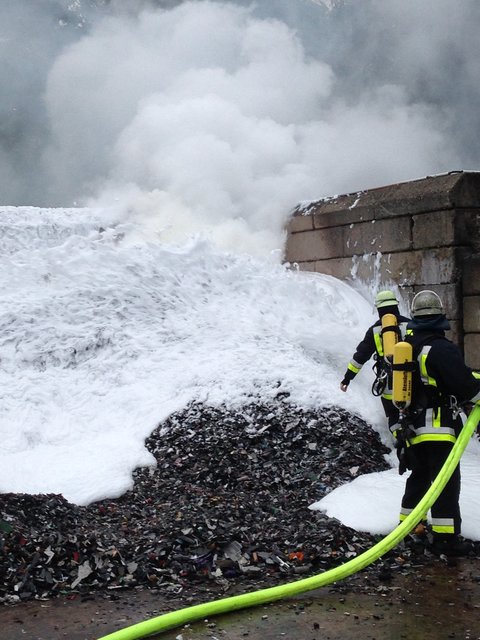 Feuerwehrleute setzen Schaummittel ein.