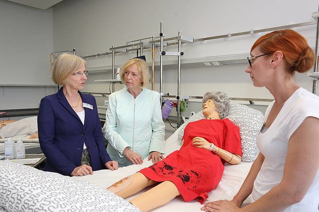 Julia Schumacher, wissenschaftliche Mitarbeiterin im Studiengang Pflege (im Bild rechts), erläuterte Bundesforschungsministerin Prof. Dr. Johanna Wanka (2.v.l.) und hsg-Präsidentin Prof. Dr. Anne Friedrichs das strukturelle und inhaltliche Vorgehen bei der Umsetzung des Themas ‚Wundmanagement bei älteren Menschen‘ innerhalb der SkillsLab-Übungen.