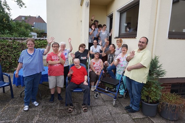 Die Bewohner der Außenwohngruppen Kreuzstraße 21, 26 und 30 freuen sich auf ihr Sommer-Sonnen-Straßenfest und laden alle Nachbarn und Freunde herzlich ein. Das Foto zeigt die Bewohner der drei Häuser vor dem Haus Nr. 21.