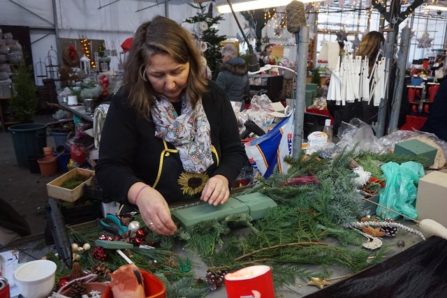 Melanie Reinertz vom Team des Monheimer Blumenmarktes fertigt ein neues Adventsgesteck an.