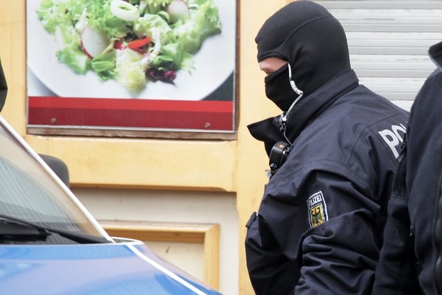Ein Polizist mit Sturmhaube steht am Mittwoch vor dem Haus an der Preußenstraße. | Foto: Magalski