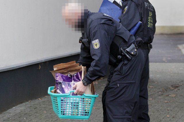 Ende der Durchsuchung: Ein Polizist trägt Beweise in einem Wäschekorb ins Freie. | Foto: Magalski