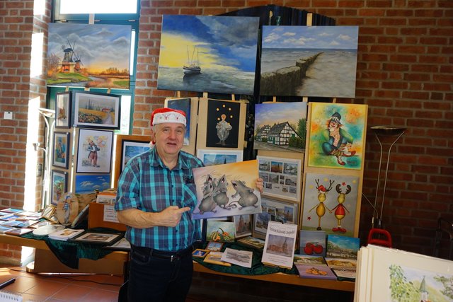 Der Richrather Kunstmaler Rolf Börnert mit seinem Bild von den singenden Mäusen - eine Anspielung auf den Kirchenchor Cäcilia.