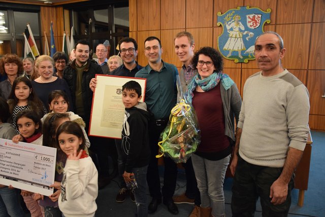Rabih Lahoud (5.v.r.) freut sich mit seiner Frau Sabrina Lahoud (2.v.r.) über die von Bürgermeister Daniel Zimmermann und Integrationsratsvorsitzendem Ercan Türkoglu (4.v.r.) überreichte Auszeichnung.