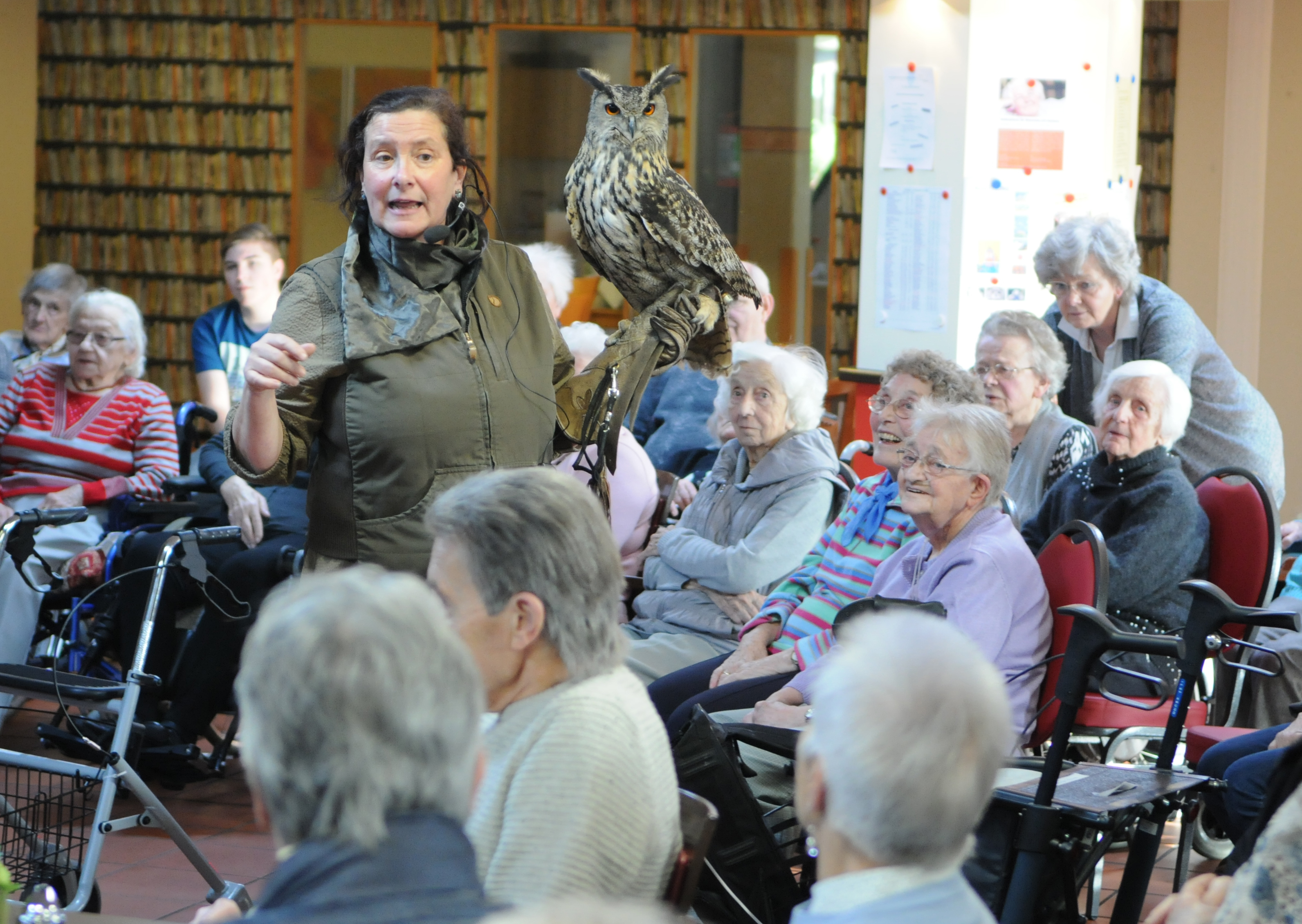 Falknerin Sabine Ehmanns-Kramp mit Uhu Fritz inmitten der interessierten Bewohner des Matthias-Jorissen-Hauses. Foto: privat