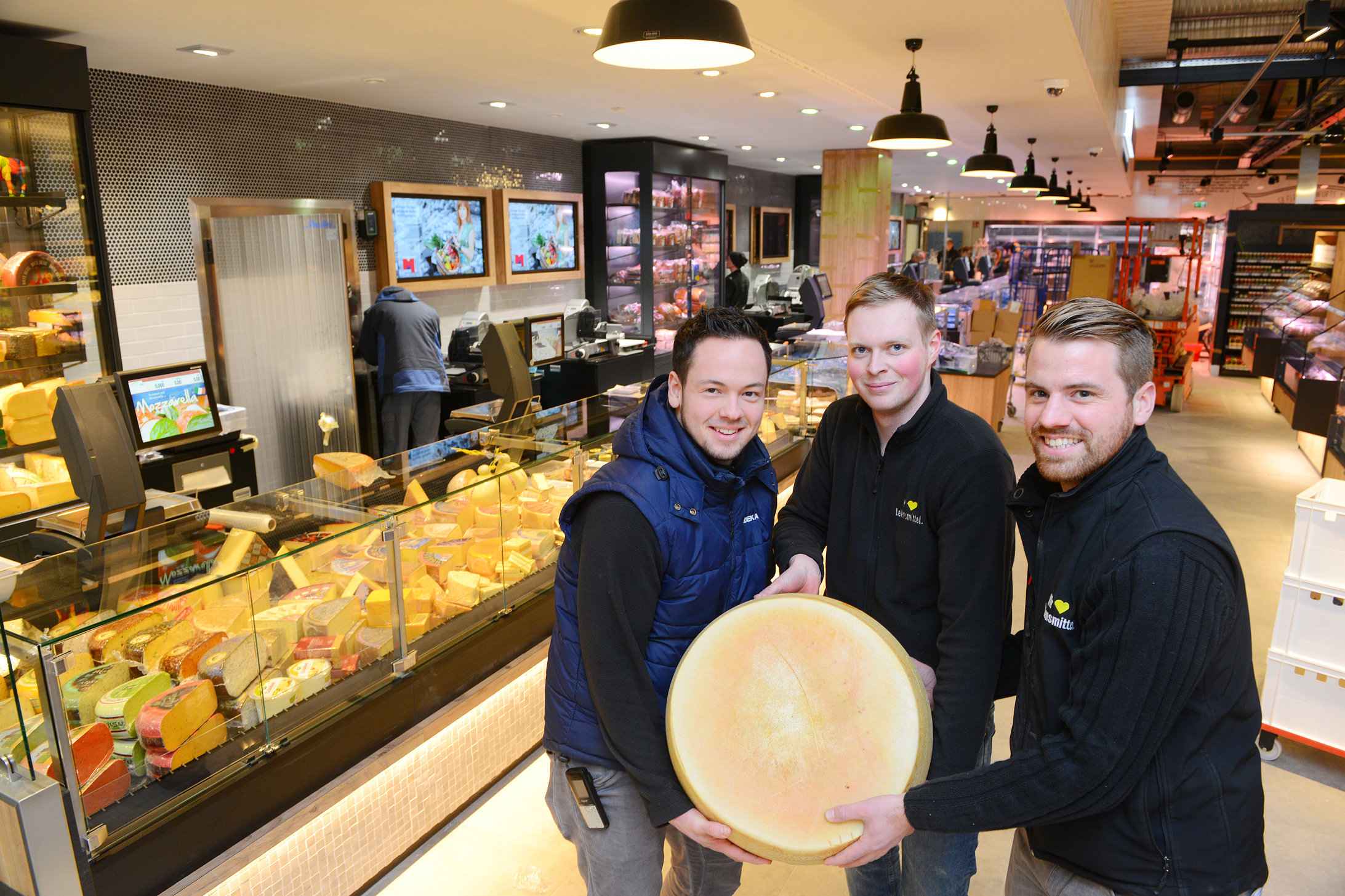 Der gesamte Frischethekenbereich ist neu konzipiert worden. Dort kommen auch alle Freunde leckerer Käse-Spezialitäten auf ihre Kosten. Auf dem Foto mit einem großen, 35 Kilogramm schweren Parmesankäse (von links): Marktleiter Patrick Tomasczyk, Kevin Wittnebel, stellvertretender Marktleiter, und Thomas Barbarski, Hauptverantwortlicher für den Markt. Fotos: de Clerque
