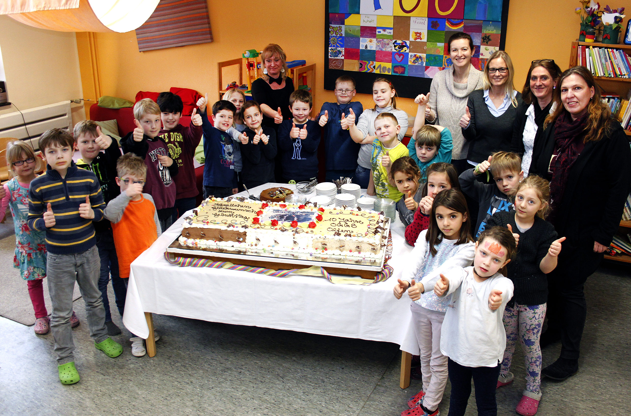 Zur Geburtstagsfeier gab es für die Kinder eine Riesentorte, von der auch Schulleiterin Petra Deuker, Daniela Damm und Michaela Nietmann von der Stadt Olfen sowie die Mitarbeiter der OGGS naschen durften.