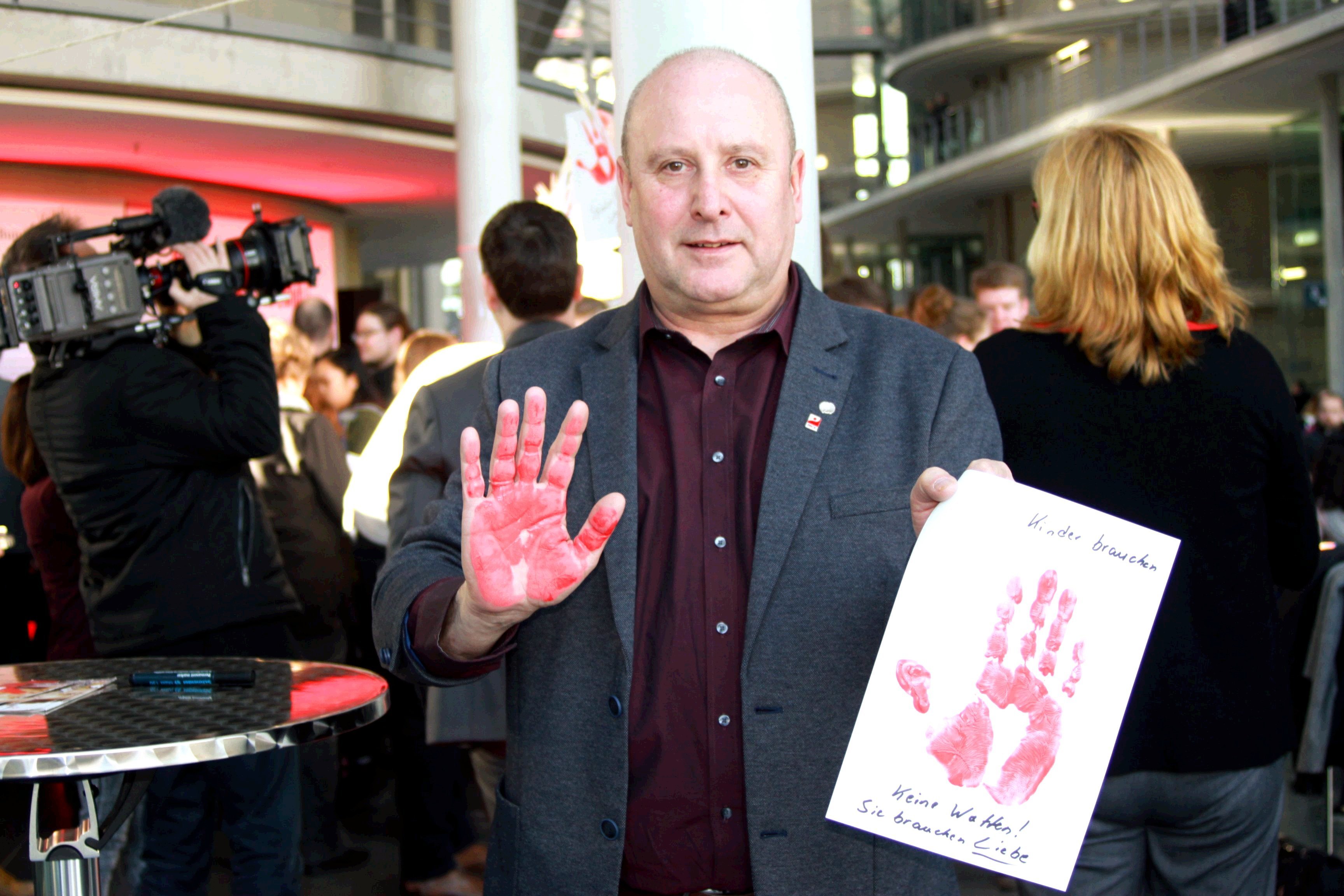 Michael Gerdes mit seinem Handabdruck gegen den Einsatz von Kindersoldaten