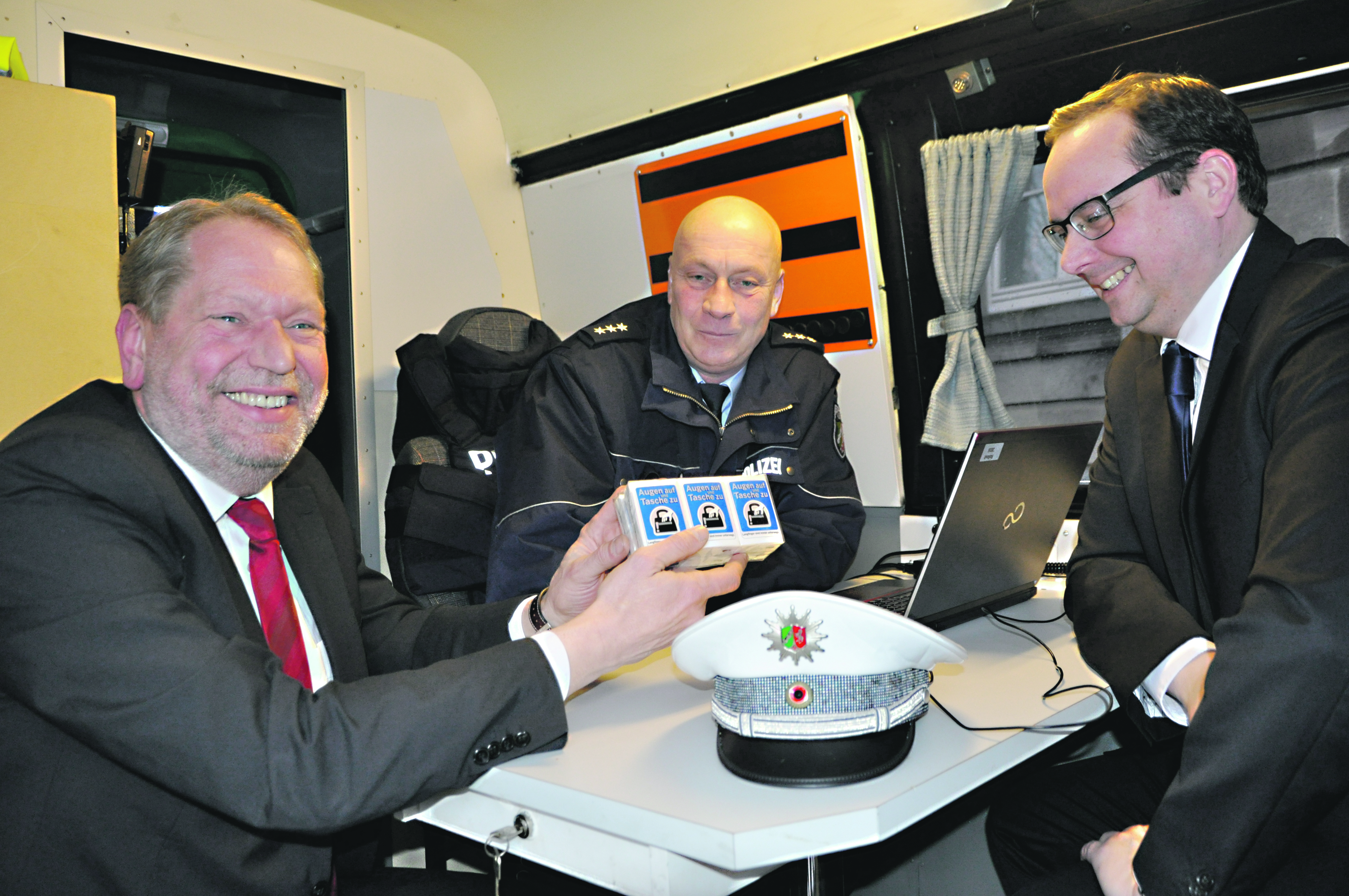Polizeihauptkommissar Andreas Ploth erklärt dem Essener Polizeipräsidenten Frank Richter und Oberbürgermeister Thomas Kufen das "Innenleben" der mobilen Wache.
