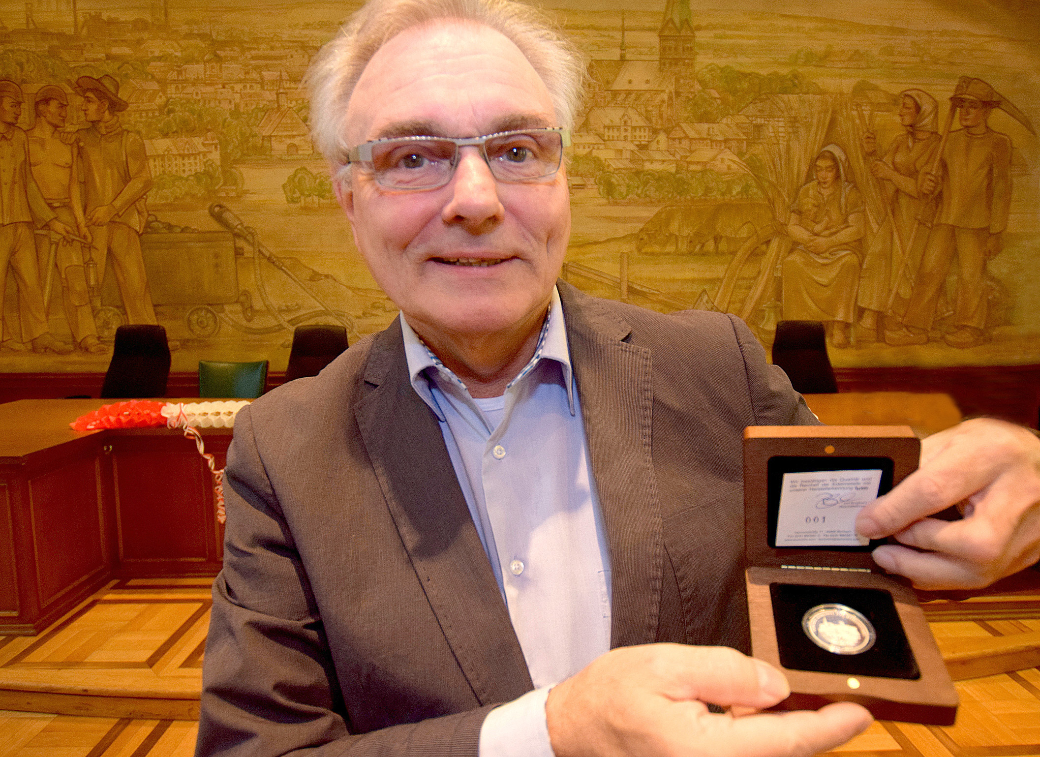 Bezirksbürgermeister Manfred Molszich präsentiert die Medaille mit der Nummer 1. Foto: Karl-Heinz Lehnertz