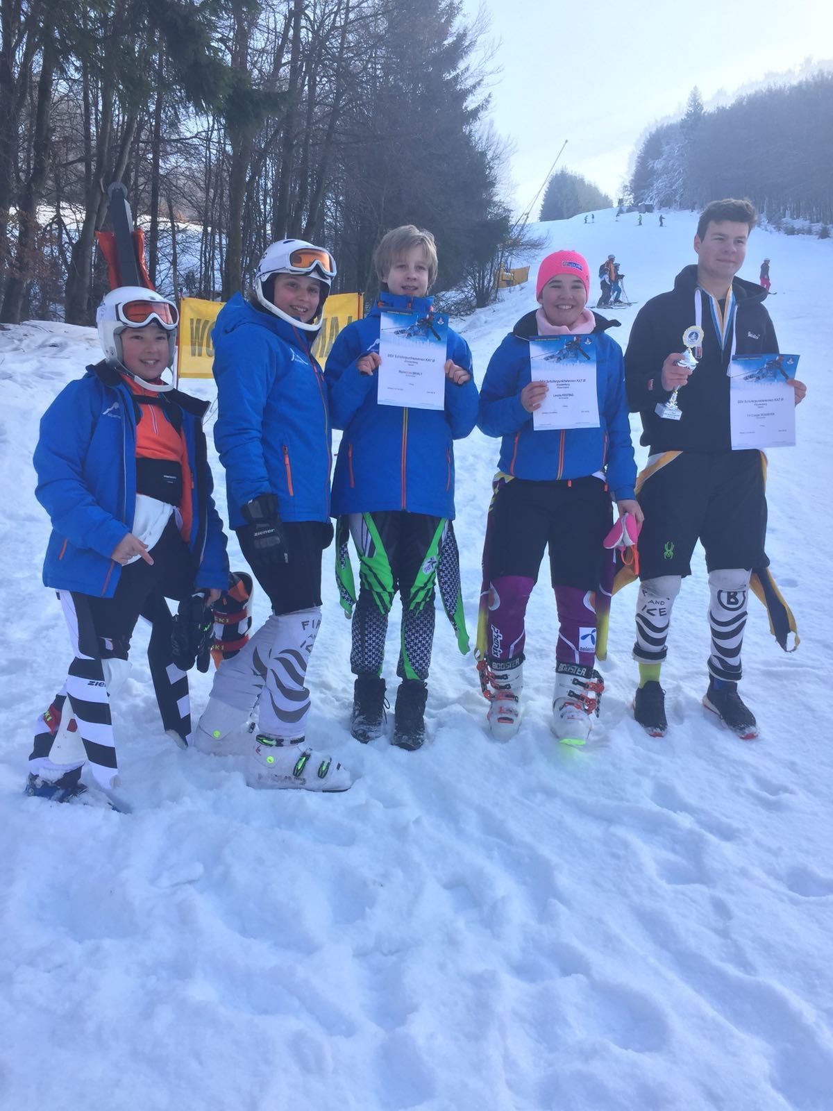 Die erfolgreichen Skifahrer zeigen stolz ihre Urkunden.