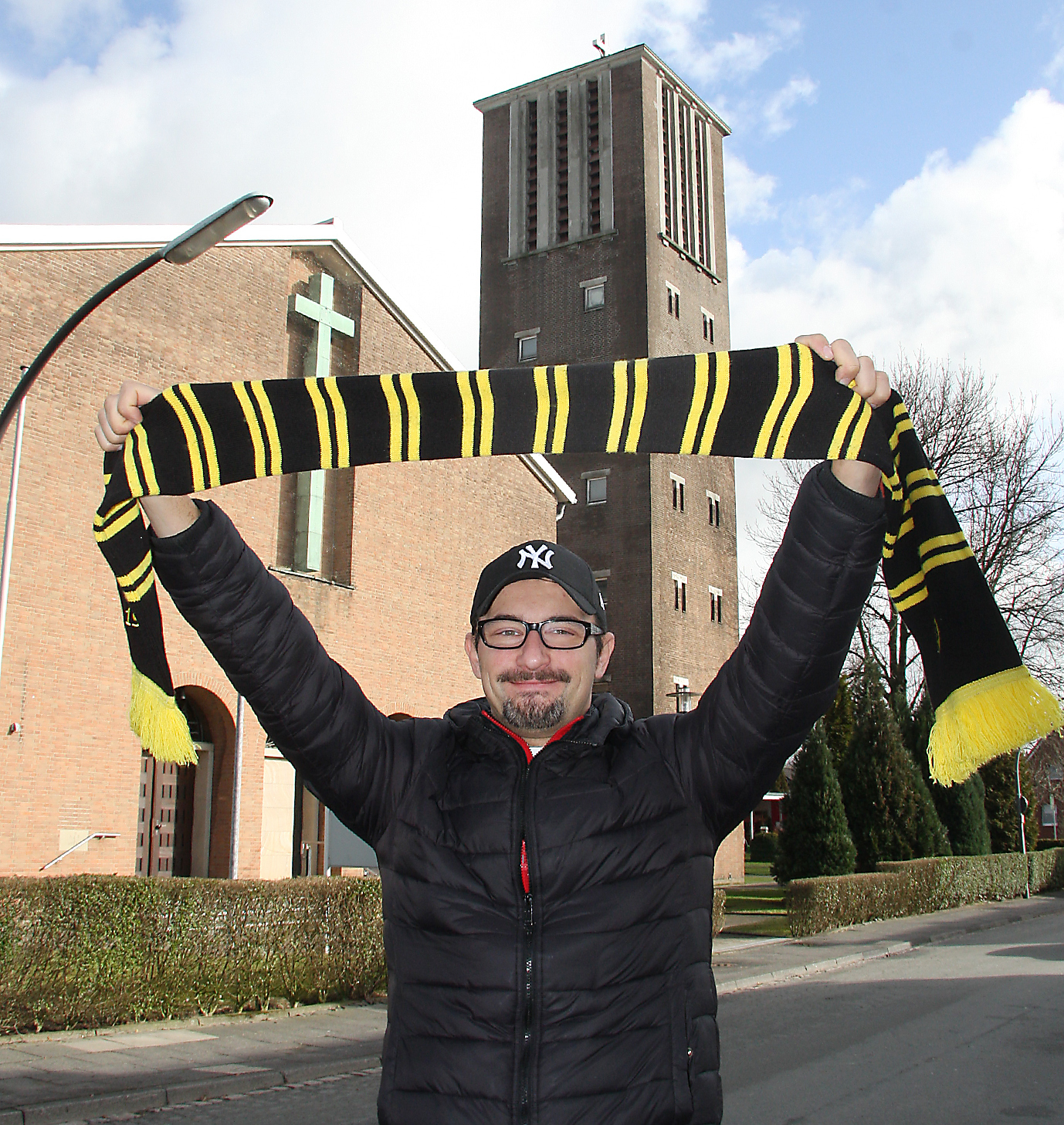 "Wer das Herz des Menschen öffnen will, wird Chirurg oder Priester", erklärt Daniel Schwarzmann (im Hintergrund die St. Barbara-Kirche − hier war er acht Jahre lang Messdiener) augenzwinkernd. Der 36-Jährige hatte sich zunächst fürs Medizinstudium eingeschrieben, entschied sich dann jedoch für den "theologischen Weg".
