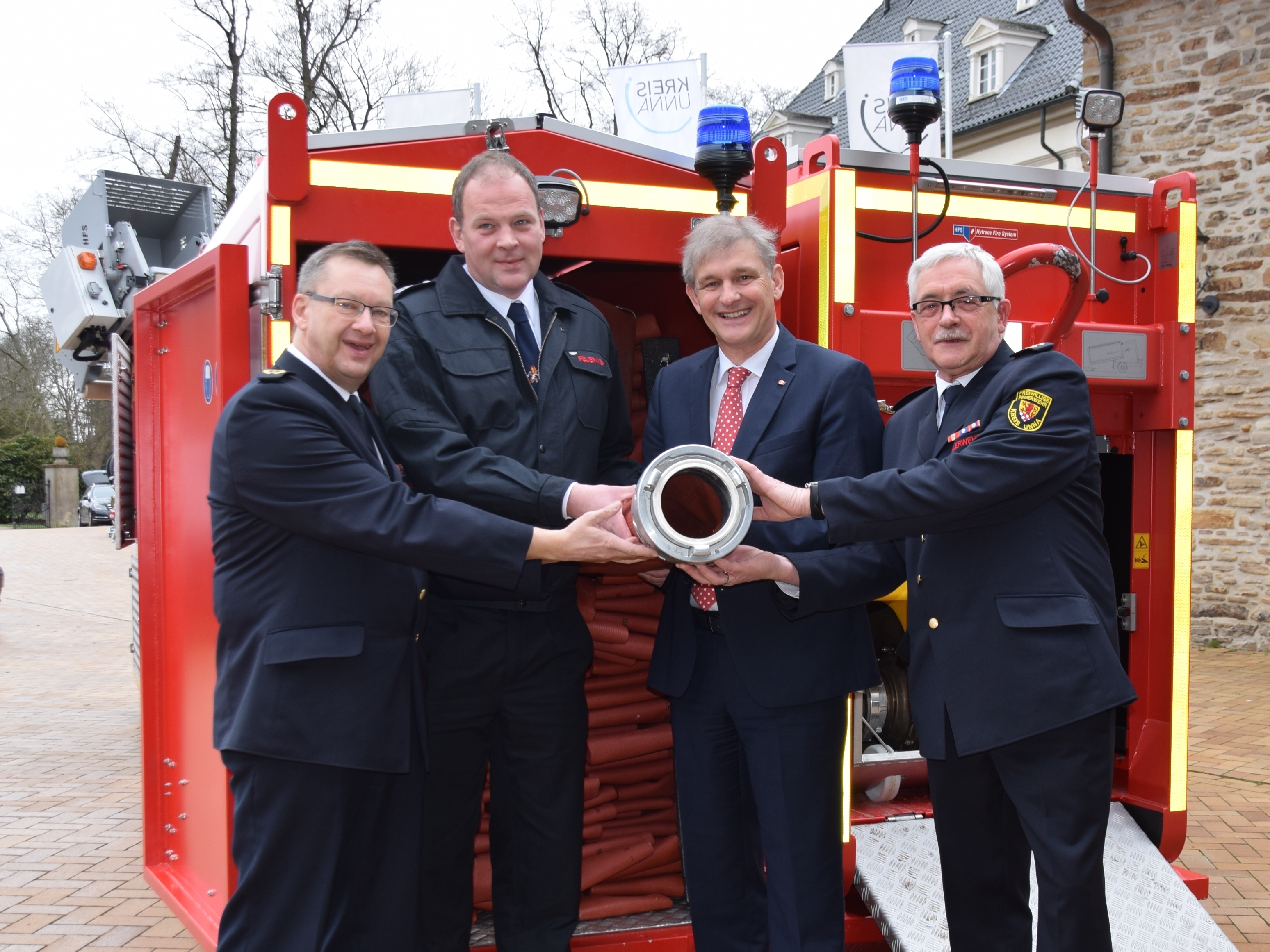 Landrat Makiolla übergab den Abrollbehälter an Unnas Feuerwehrchef Hendrik zur Weihen (2.v.l). Mit dabei Bezirksbrandmeister Weidenbeck (l.) und Kreisbrandmeister Peukmann.