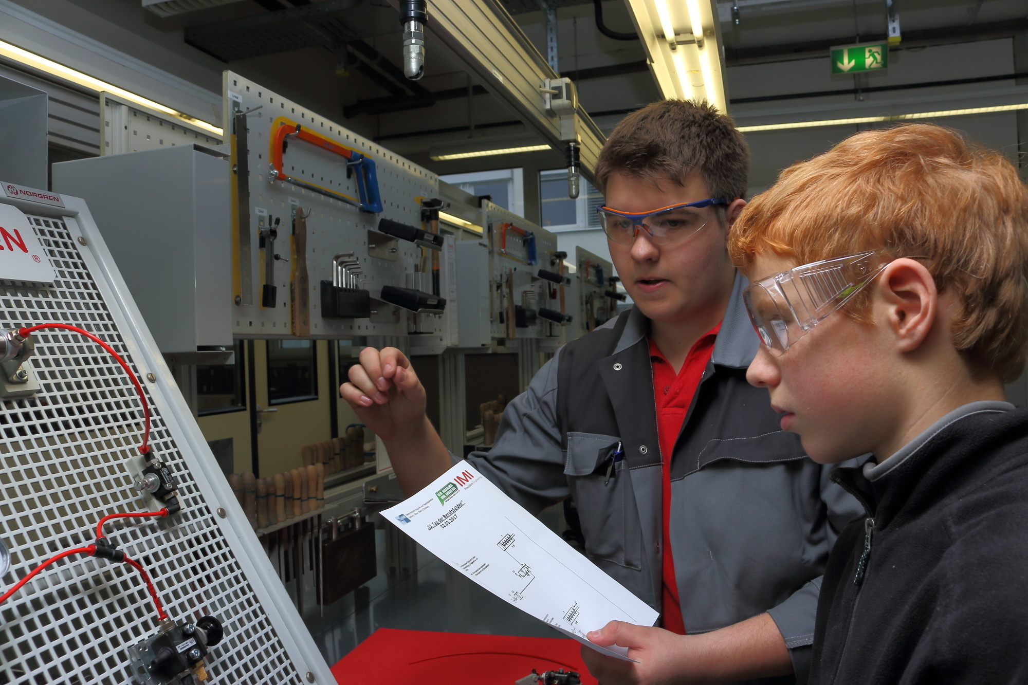 Der Auszubildende Marvin Riedel (3. Lehrjahr) erklärt Simon Pfau (13) aus der 8. Klasse des Rheinberger Amplonius Gymnasiums die pneumatische Installation an einem Übungsstand. Simon ist nach eigenen Angaben sehr an Technik interessiert und bastelt auch gerne zu Hause mit seinem Technikbaukasten. Sein Berufswunsch nach dem Abitur: "Ingenieur im Maschinenbau."