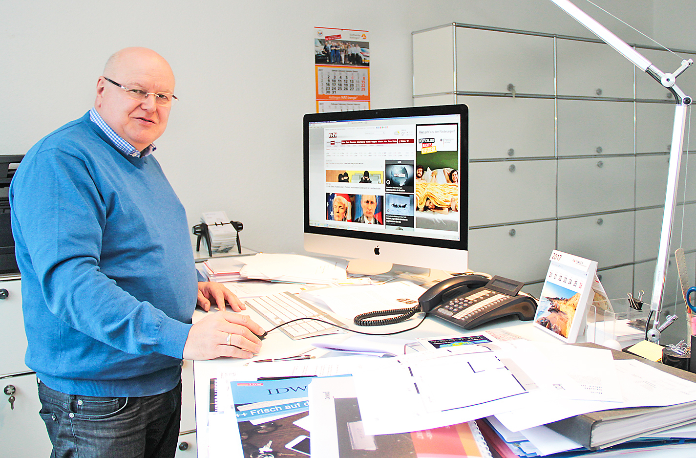 Jürgen Wille, Geschäftsführer der Stadtwerke Hattingen GmbH, an seinem Schreibtisch, der nach sehr viel Arbeit aussieht. Foto: Römer