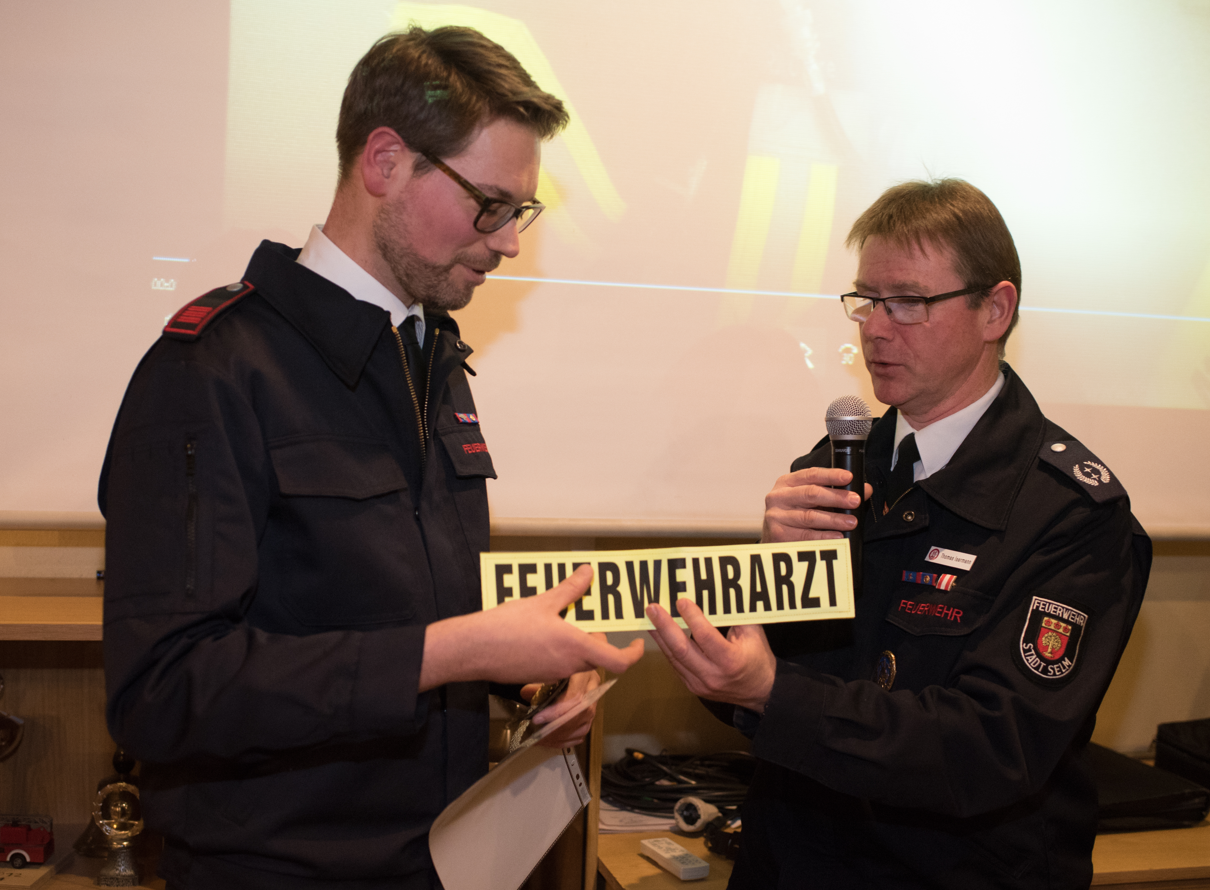 Eric Lipke, links, erhält seine Ernennung zum Feuerwehrarzt von Wehrführer Thomas Isermann