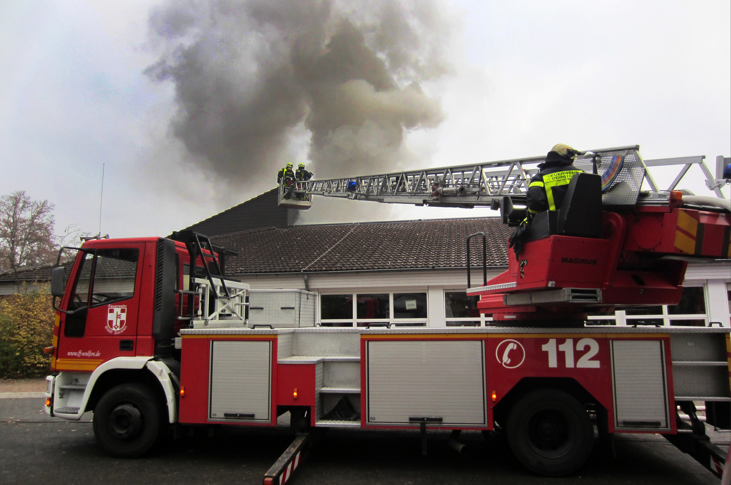 Foto: Bludau - 04.12.2013 - Dorsten
Am Mittwochmorgen kam es in der Werkstatt für Behinderte in Wulfen zu einem größeren Brand. Kurz vor 10.00 Uhr wurde die Feuerwehr Dorsten mit insgesamt vier Löschzügen zur Thüringer Straße alarmiert. Schon auf der Anfahrt konnten die Einsatzkräfte eine dunkle Rauchsäule erkennen. Parallel zur Alarmierung hatten die Mitarbeiter bereits mit einer Evakuierung der Mitarbeiter begonnen. Als die ersten Feuerwehreinheiten eintrafen hatten alle Personen unverletzt das Gebäude ve