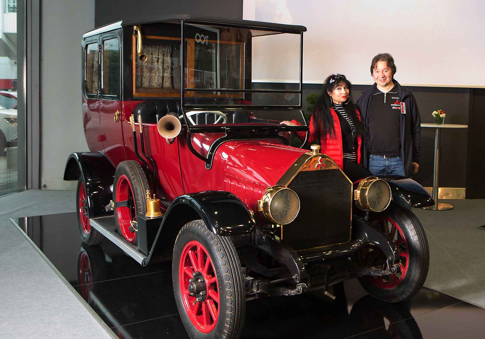 Schnappschuss mit Dirk Murawski und Lebenspartnerin Lydia Menn beim Mitsubishi-Händlertag in den Messehallen in Frankfurt vor dem ersten Mitsubshi-SerienAutomobil, dem Modell A. Dieses wurde zwischen 1917 und 1921 ganze 30-mal gebaut und galt mit 34 PS und sieben Sitzplätzen schon damals als „Raumwunder“. Foto privat