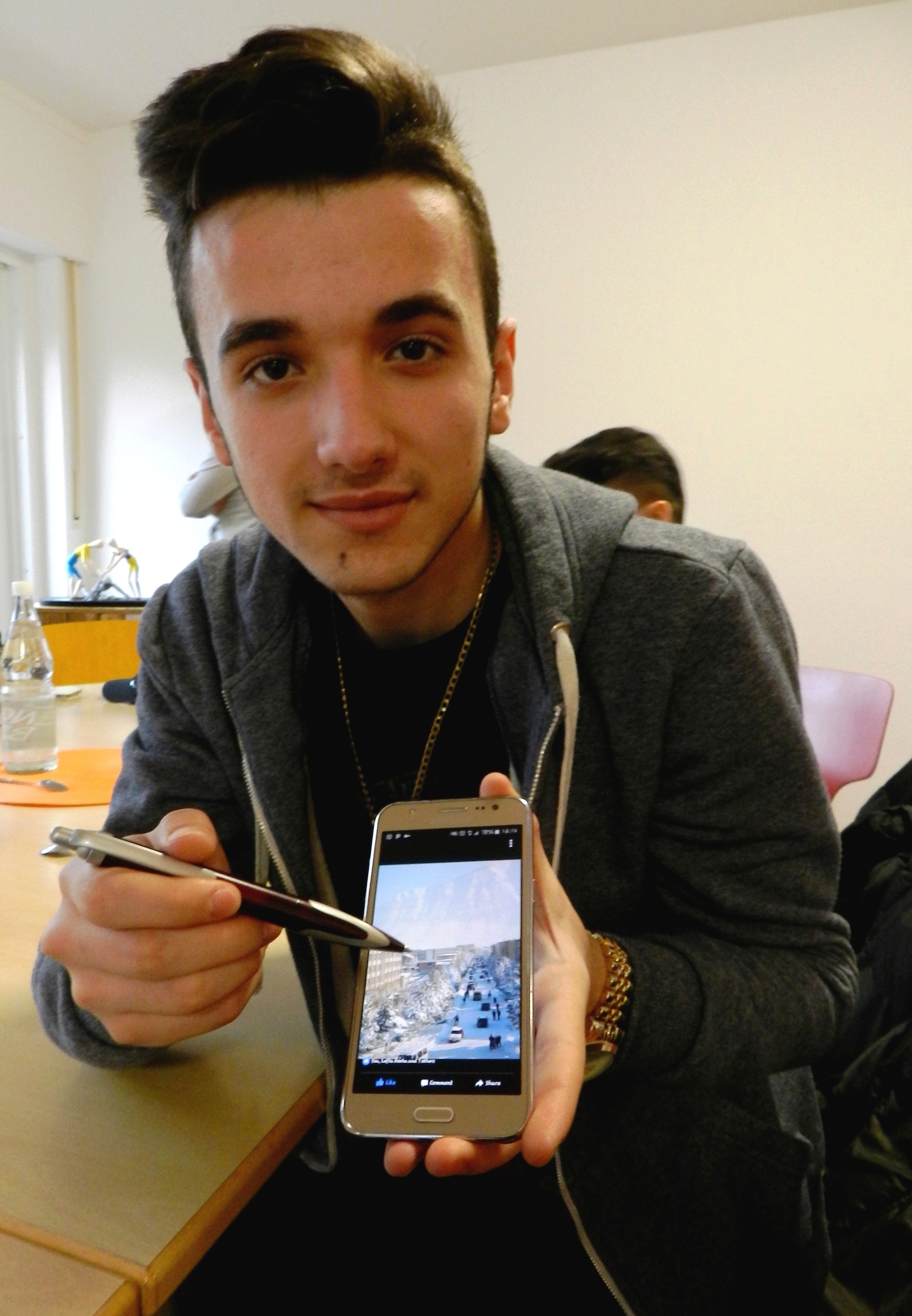 Wie für alle Flüchtlinge ist auch für Denis (17) das Smartphone die einzige mögliche Verbindung zu seinen Eltern, Geschwistern und Freunden in der Heimat. Hier zeigt er stolz ein Foto von seinem Wohnort in Albanien.