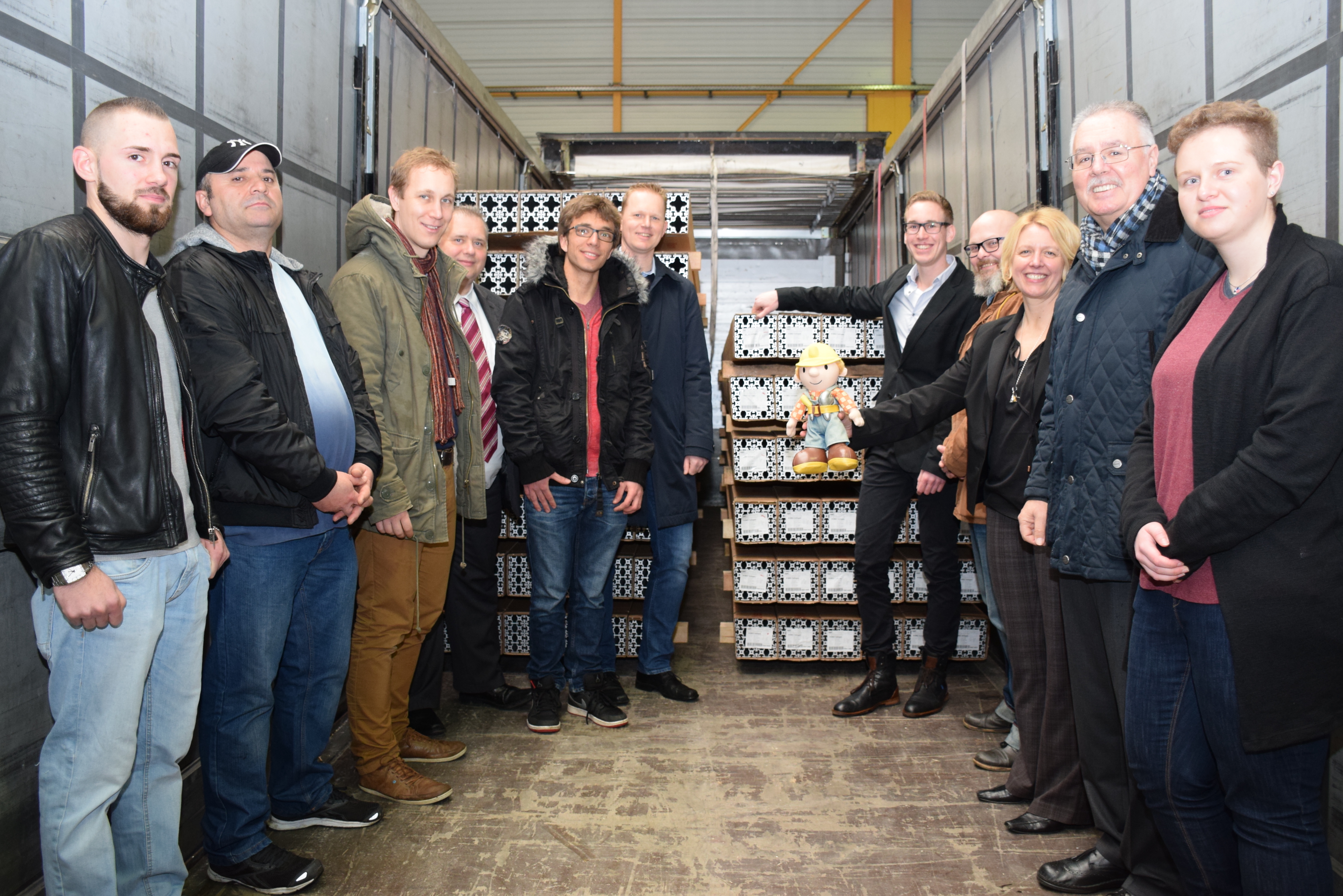 Tim Schneider (hinten rechts, Assistent der Hilgers-Geschäftsleitung), Monheims Bürgermeister Daniel Zimmermann (3. v. l.), Hans-Dieter Clauser (2. v. r.), Marcus Kowalczyk (4. v. l., Agentur für Arbeit), Petra Mackenbrock (3. v. r.) und Lisa Clevenhaus (r., Wirtschaftsförderung Monheim), Holger Eckert (Mitte, Wirtschaftsförderung Langenfeld) sowie Azubis und Ausbilder der Firma Hilgers.
